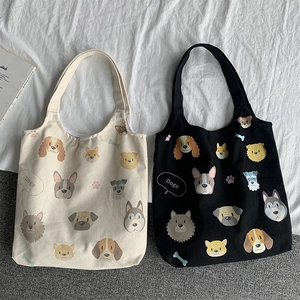 Detail of black and beige canvas tote bags with all-over cartoon dog heads pattern