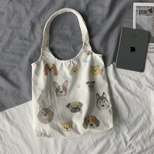 Detailed view of canvas tote bag featuring cute cartoon dog illustrations and Dogs text
