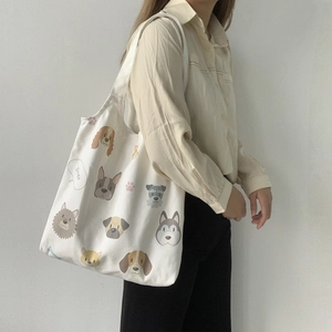 Detail of white canvas tote bag with various cartoon dog illustrations and Dogs text print