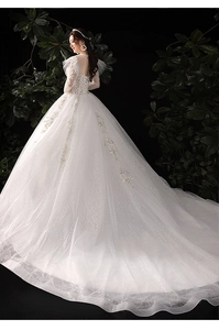 Vue arrière d'une robe de mariée en dentelle avec traîne luxueuse sur fond sombre élégant