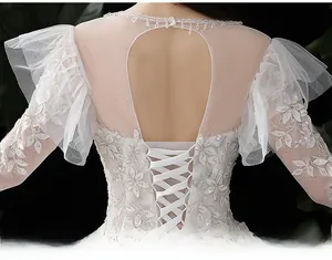 Vue détaillée du dos d'une robe de mariée en dentelle avec découpes et laçage croisé