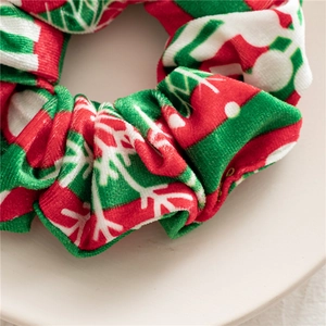 Detailed view of red velvet Christmas scrunchie with white snowflake patterns