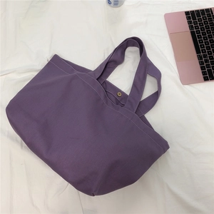 Detail van de paarse canvas tas met metalen drukknoop en stevige brede schouderbanden