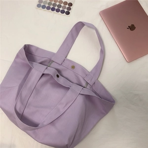 Platliggende lavendel canvas draagtas met metalen drukknoopsluiting en laptoptas