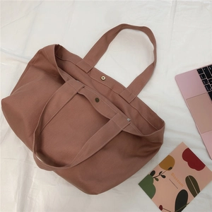 Detail van oudroze canvas shopper met magnetische sluiting en brede schouderbanden