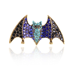 Vintage bat brooch in gold metal with navy and light blue rhinestones on white backdrop