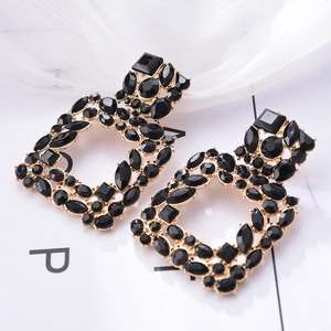 Close-up of vintage geometric square stud earrings with black crystals and gold metal