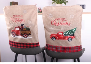Detail of burlap Christmas chair covers featuring red truck and snowflake prints