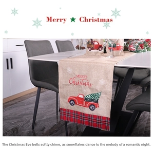 Detail view of linen Christmas table runner with red truck and green plaid trim decor