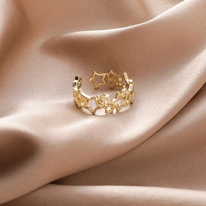 Adjustable gold star ring with micro-pave zircon crystals on champagne silk background
