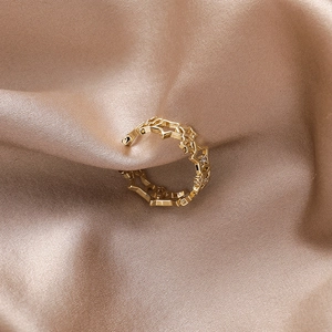 Detailed view of adjustable gold star ring with micro-set diamonds on champagne silk