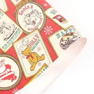 Vintage red Christmas wrapping paper with Santa and teddy bear stamps in a roll