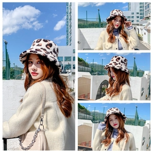 Outdoor street style view of a woman wearing a leopard print faux fur bucket hat