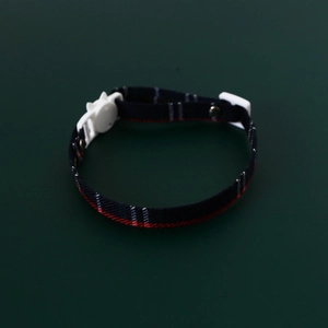 Detailed view of the navy blue plaid pet collar with a white cat-shaped safety buckle