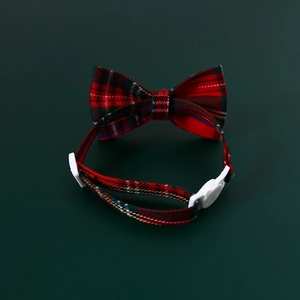 Detail of red and green plaid pet collar with a double bowknot and white buckle clasp