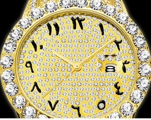 Close-up of gold iced-out watch with full rhinestones and black Arabic numerals