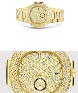 Close-up of gold iced-out quartz watch dial featuring crystal encrusting and date window