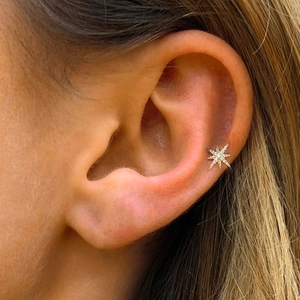 Macro shot of gold S925 silver star ear cuff with sparkling zircon inlay for women