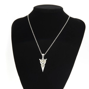 Detail of silver arrowhead pendant with vintage matte finish on black velvet display stand