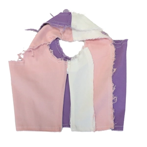 Detailed view of color-block patchwork crop top with frayed edges and front zipper closure