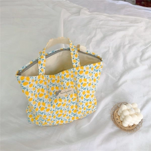 Detail of yellow lemon pattern floral canvas handbag with a secure zipper closure