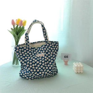 Close-up of floral cotton tote bag with white flower patterns on a checkered tablecloth