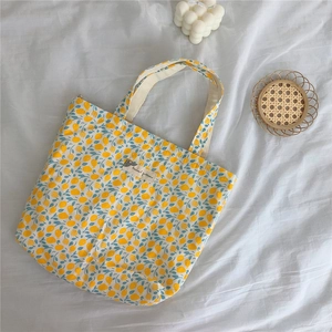 Detailed close-up of a floral cotton bag with lemon prints on a white fabric surface