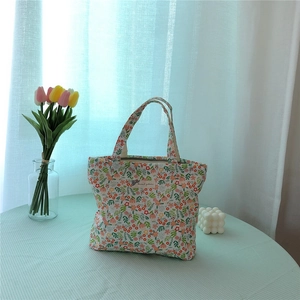Floral print cotton lunch bag on a checkered tablecloth with soft sunlight detail