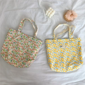 Flat lay of floral and lemon print cotton canvas mini tote bags with beige handles
