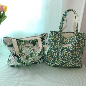 Detail of floral and cactus print cotton lunch bags on a green checkered tablecloth