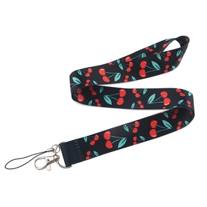 Detail of cherry pattern print on black phone lanyard with silver metal lobster clasp
