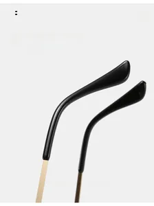 Dettaglio delle stanghette curve in metallo nero e oro degli occhiali da sole a cuore