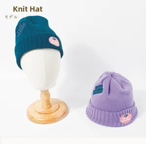 Close-up of thick knitted bucket hats with colorful embroidery for winter warmth