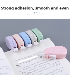 Close-up of five colorful capsule correction tapes on an open book for school