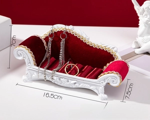 Detail of European style sofa jewelry display stand with red velvet slots and white frame
