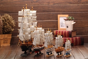 Set of five Mediterranean wooden sailboat models with striped fabric sails and rigging