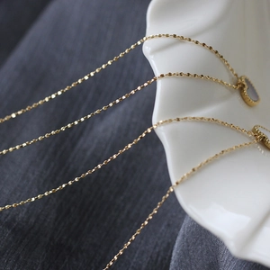 Macro shot of 18K gold plated heart necklace with white shell inlay on a ceramic plate