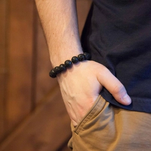 Men's matte black lava stone beaded bracelet worn on wrist for a rugged minimalist style