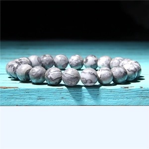Macro detail of 8mm natural striped agate beads on a rustic blue wooden background