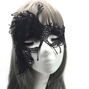 Close-up of black lace masquerade mask with peacock feather patterns on a model