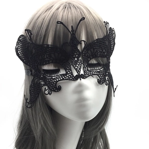 Close-up of intricate black lace butterfly mask showing hollow patterns on mannequin