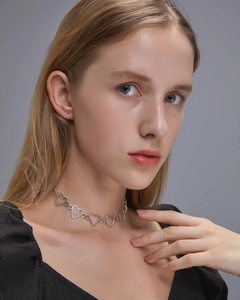 Nahaufnahme eines silbernen Chokers mit Herz-Hohlraum-Design an einem Model-Hals