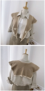 Front and back detail of a beige knitted shawl with heart pattern on a mannequin