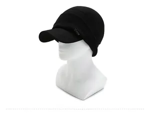 Close-up of black winter knit hat with earflaps and metallic fashion badge detail