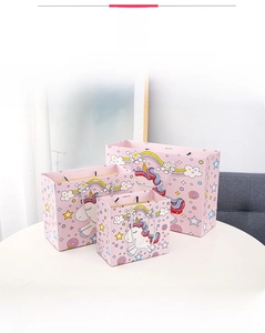 Three sizes of pink unicorn gift bags with rainbow patterns and silver braided handles