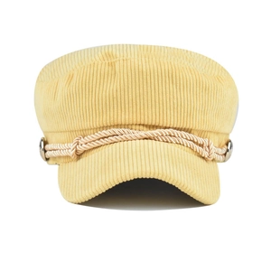 Detail of yellow corduroy newsboy hat featuring decorative braided rope and metal buttons