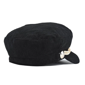 Detail view of black corduroy baker boy hat with decorative braided rope and silver button