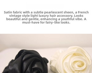Close-up of black and cream satin scrunchies with pearlescent finish and soft texture