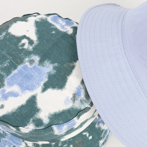 Reversible tie-dye and light blue bucket hat with reinforced stitching for sun protection