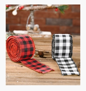 Macro detail of red and black buffalo check Christmas ribbons on rustic wood